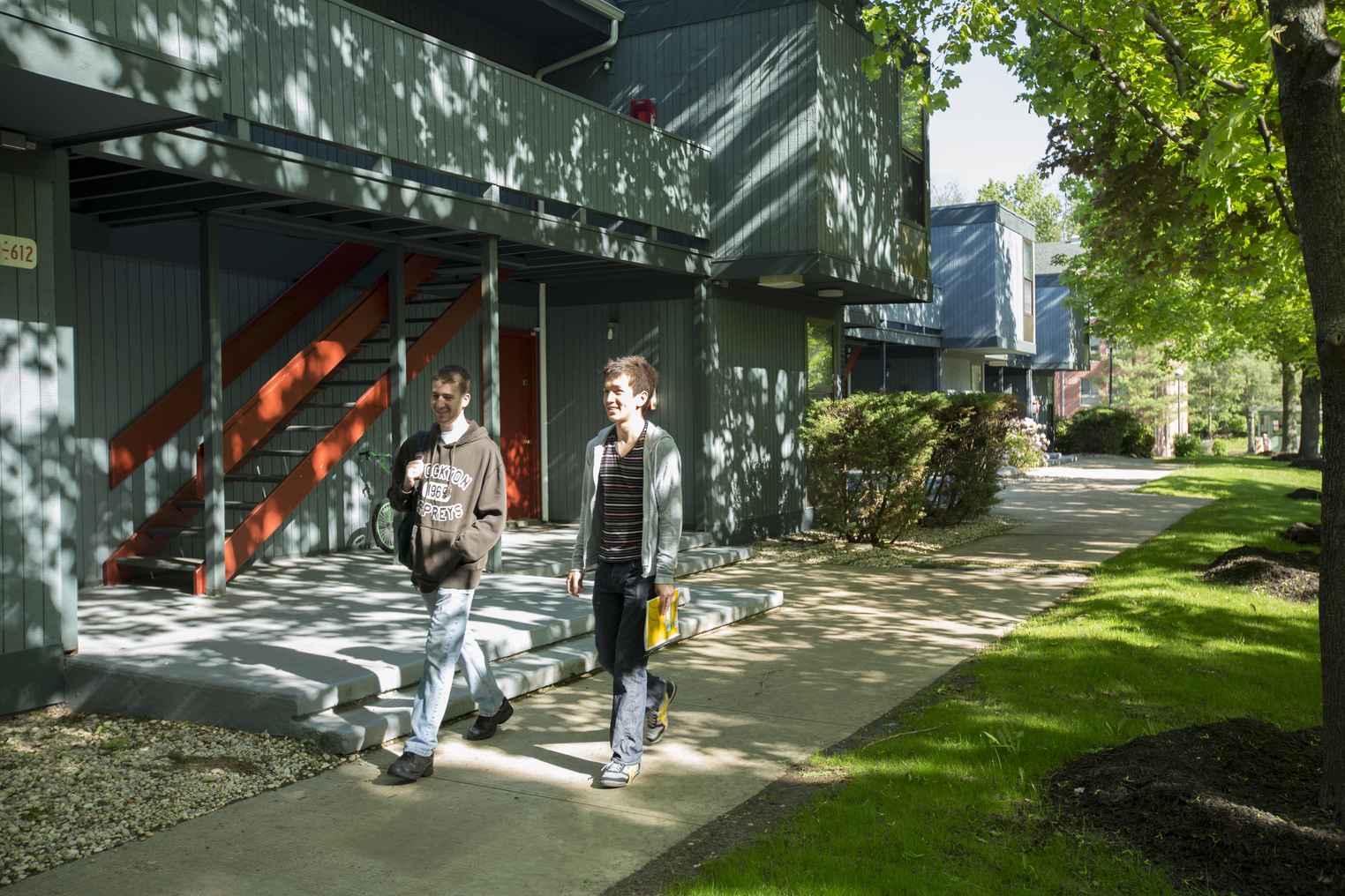 Two students walking on sidewalk outside Grasslands I