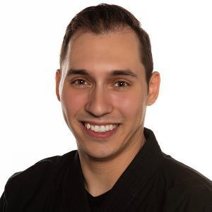 Benjamin Andersen smiling headshot from above the shoulders in front of white backdrop