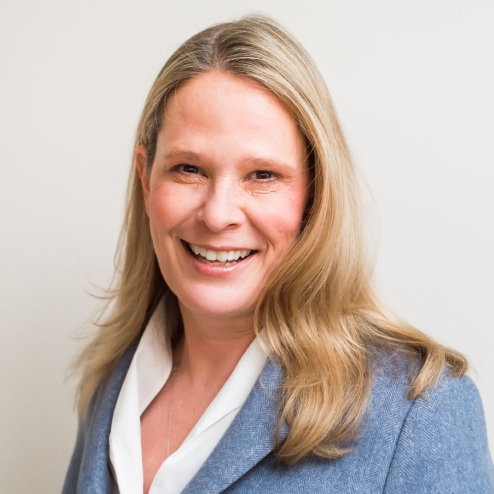 blond woman wearing blue suit jacket and white shirt