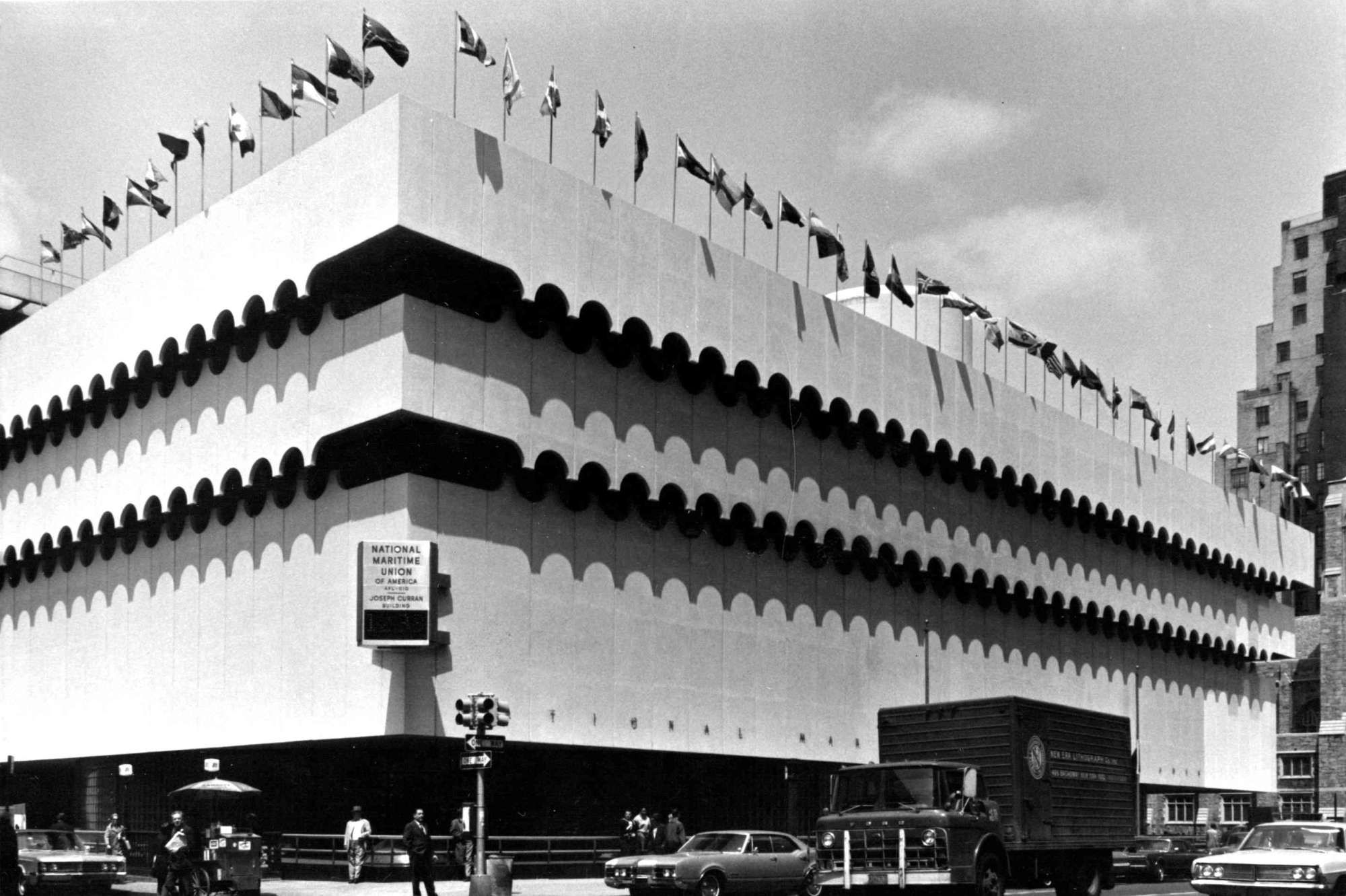 The O’Toole Building, where St. Vincent’s Comprehensive HIV Clinic was located. Large, multi-story building with scalloped trim, and flags of different countries lining the roof