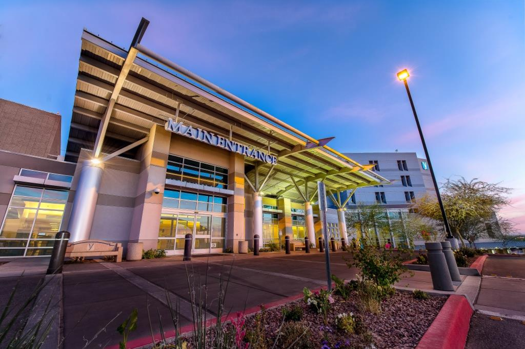 Main entrance of YRMC. Modern design with lots of windows and shrubbery outside