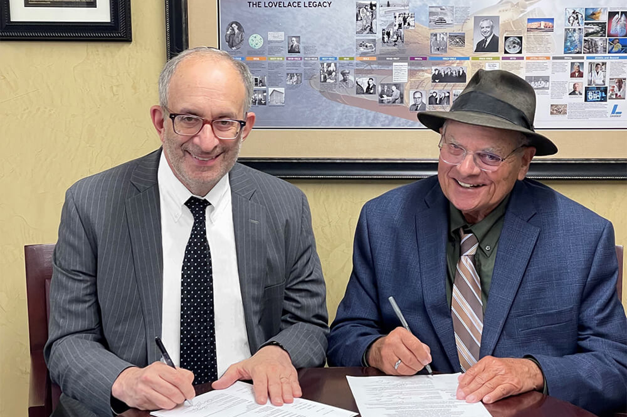 Dr. Kadish and the CEO of Lovelace Research Institute, Robert W. Rubin, smiling together at a table while signing the documents for Lovelace to join Touro and NYMC