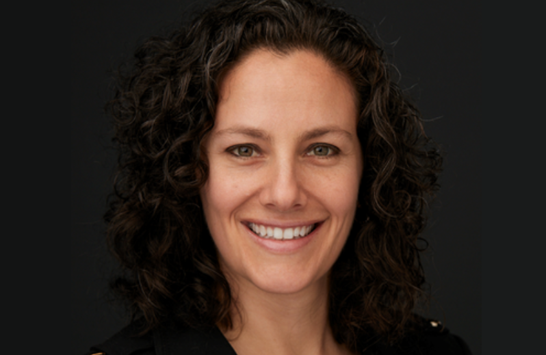 Woman smiling in front of dark background