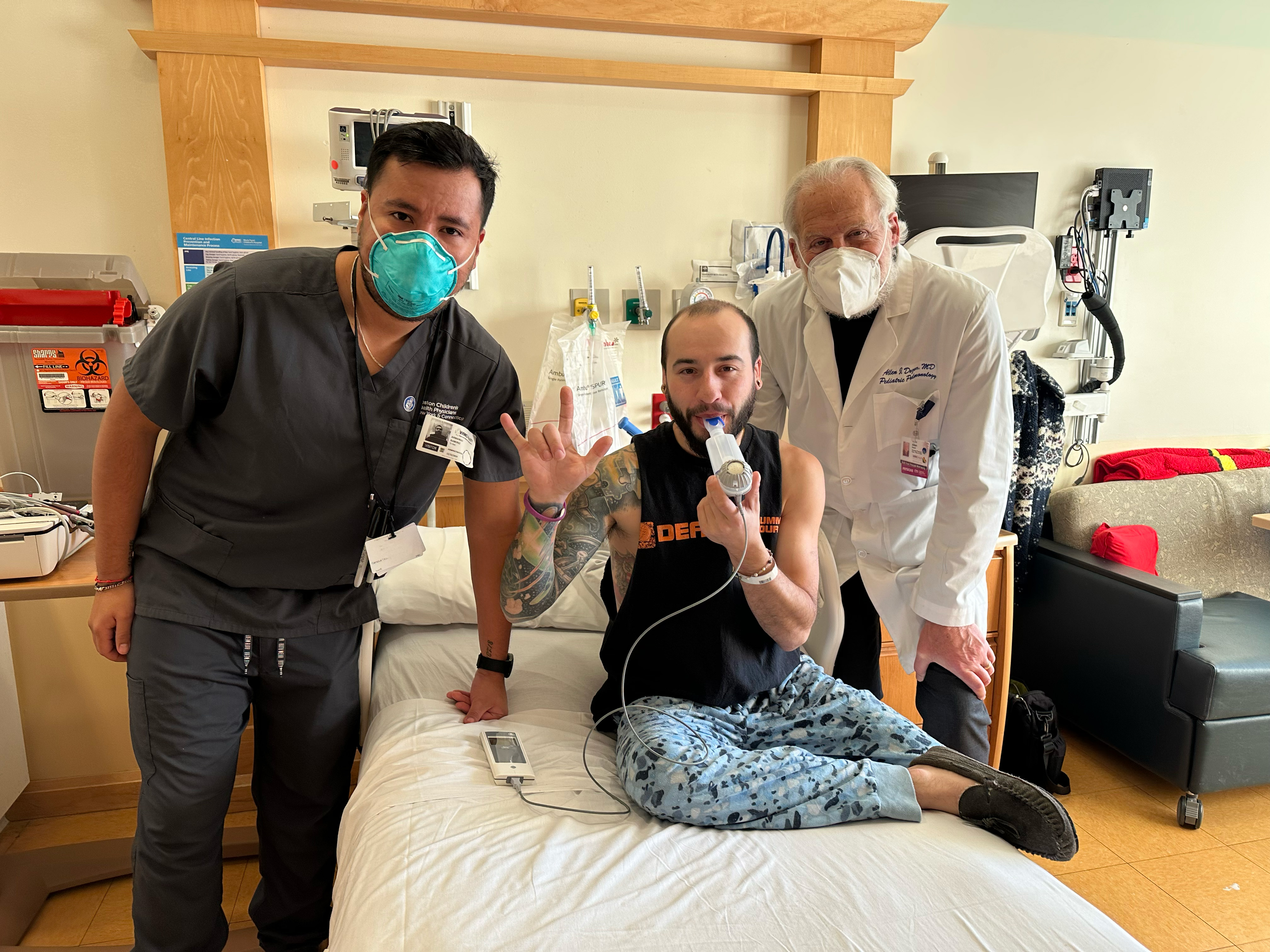 A male patient in a hospital room with medical professionals.