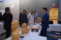a group of attendees gathered around a table with displayed mannequins from the CSSC expansion reception
