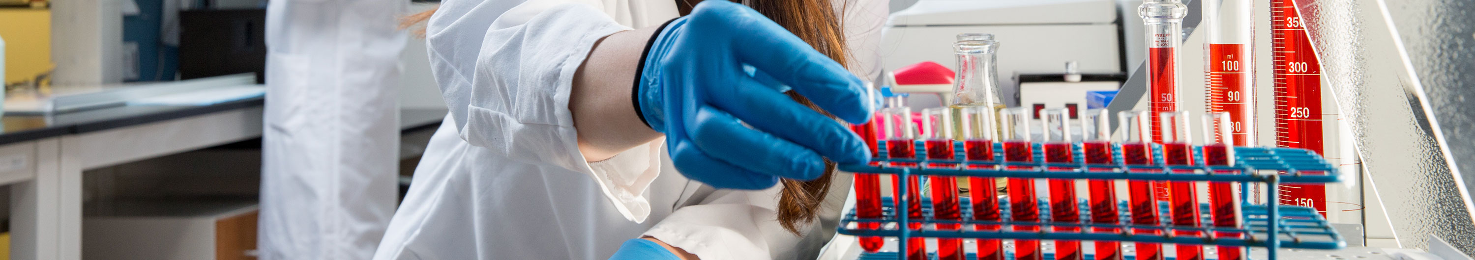 NYMC student working with vials of liquid in lab