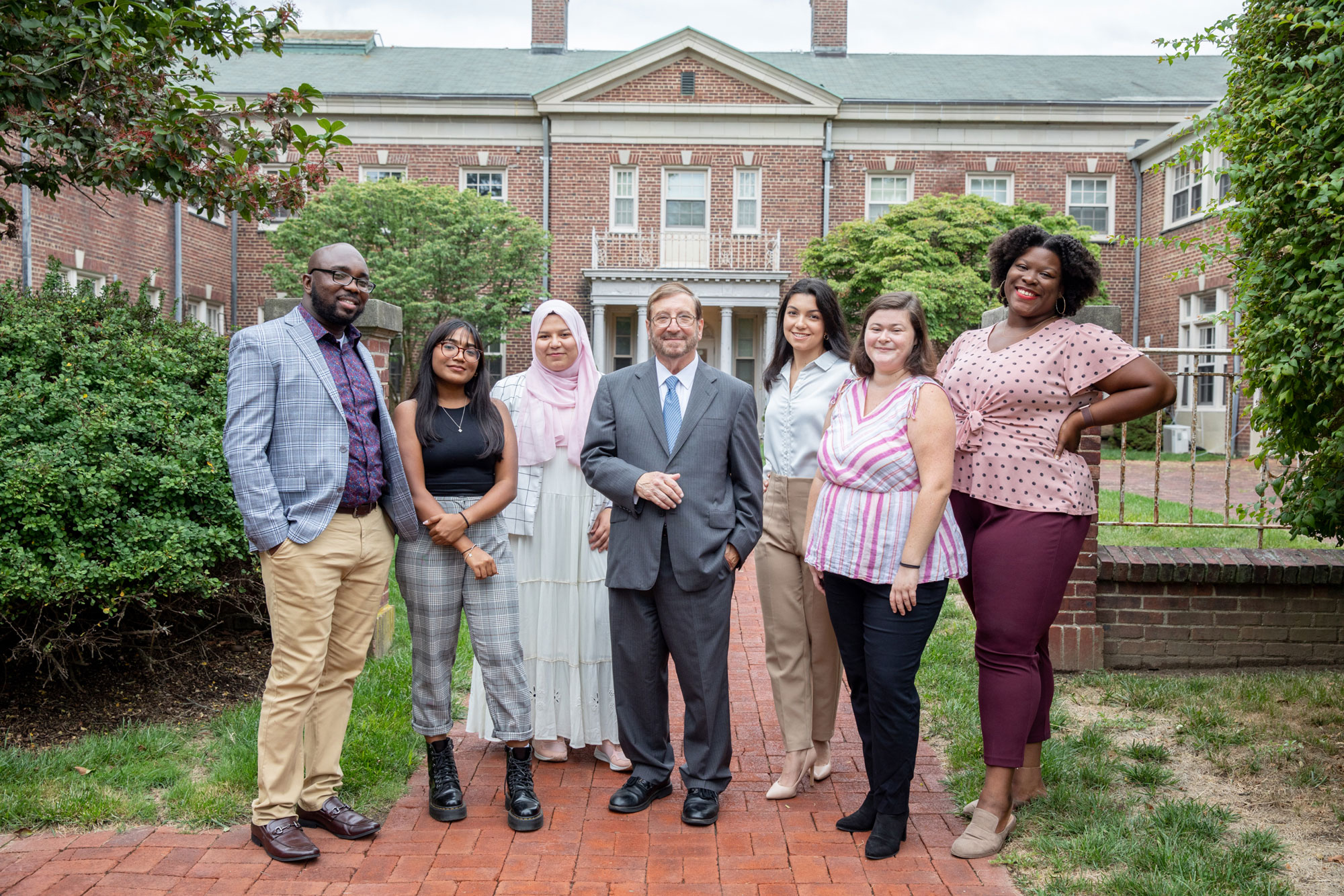 Group of SHSP students smiling and posing with Dean in front of school building