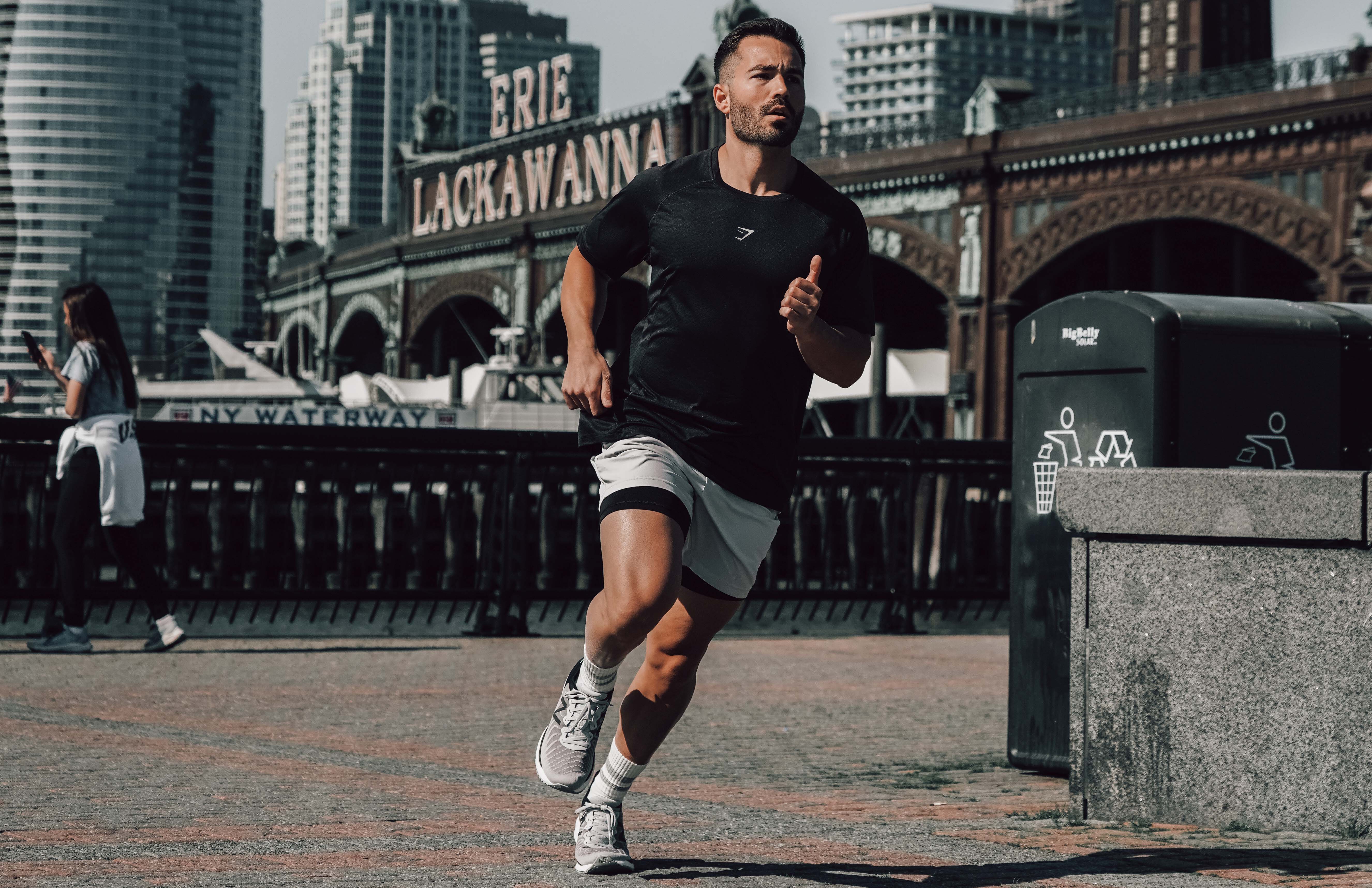 Man, running in stride, in front of city backdrop