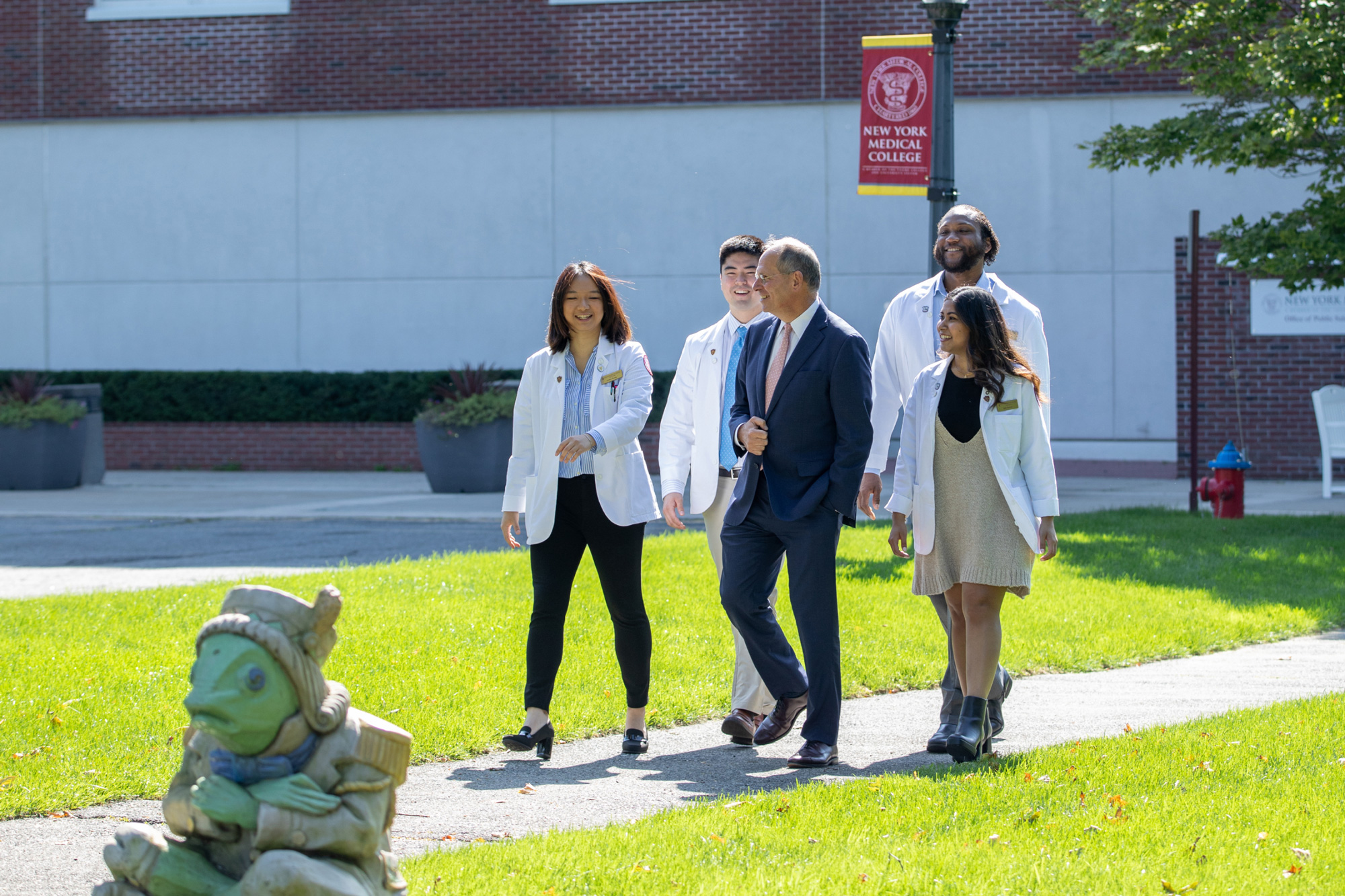 SOM students smiling while walking on campus with Dean