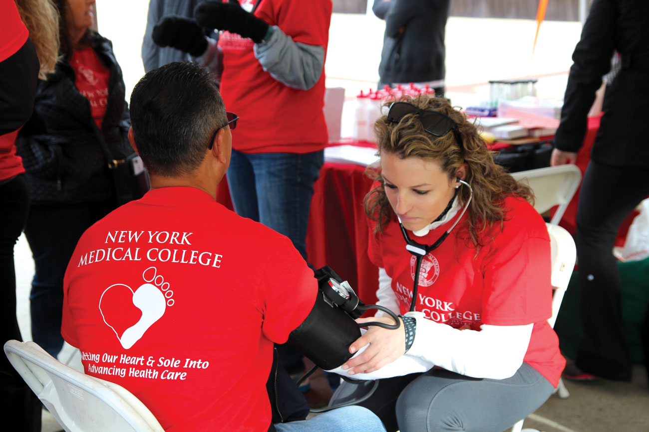 NYMC student taking blood pressure of patient